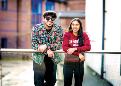 A couple of students leaning on a railing